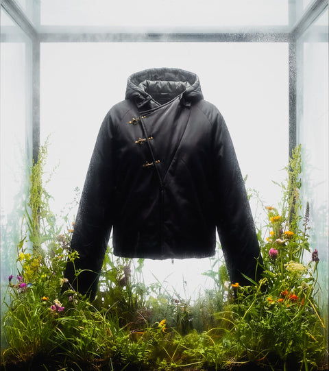 Jacket Hanfu standing inside a glass box with a natural outdoor setting