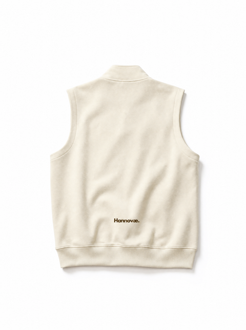 A cream-colored sleeveless fleece vest shown from the back, featuring a small black 'Hannovae' logo near the lower back, set against a plain white background.