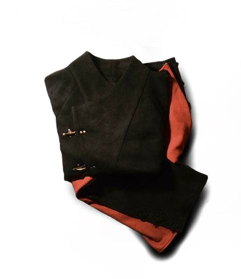 Folded black and orange garment on a white background