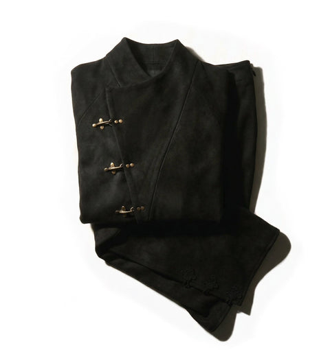 Folded Hannovae black jacket with gold buttons on a white background